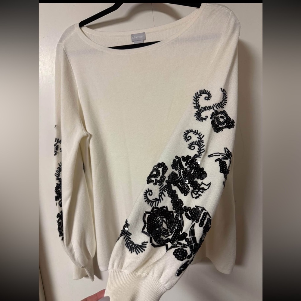 Chico’s- Cream Sweater with Black Embroidery/sequins on sleeves size 3
4